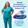 Lächelnde Frau in türkisfarbener Arbeitskleidung steht neben zwei Einlegesohlen. Text: Beugt Ermüdung bei stundenlangem Stehen vor – Einlegesohlen für ganztägigen Komfort und Ausdauer.